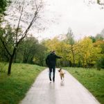man walling with dog in park