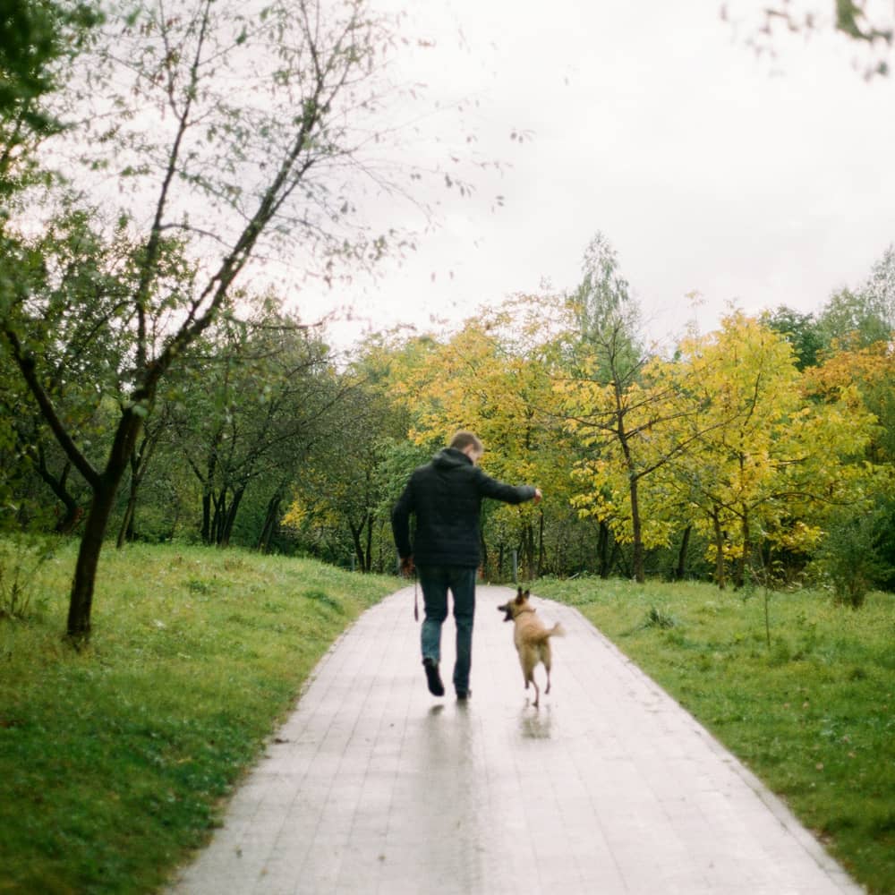 man walling with dog in park